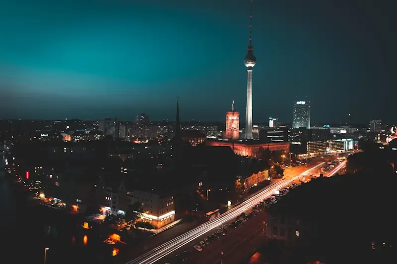 Nachtaufnahme von Berlin mit beleuchtetem Fernsehturm und Straßenlichtern im Vordergrund